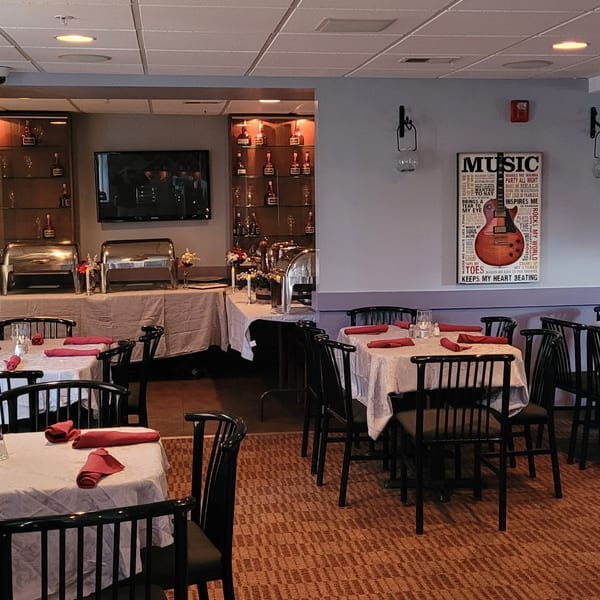 An empty dining room at Stan & Joe's Saloon with tables set and a buffet area.