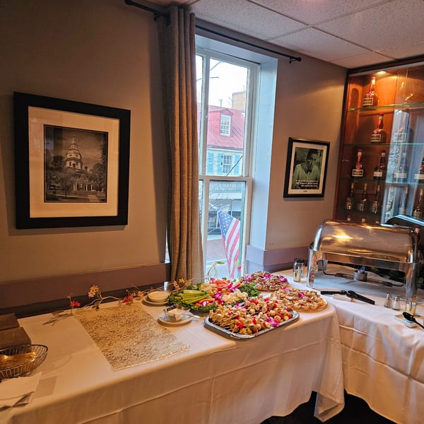 A buffet table with appetizers, a vegetable platter, and a chafing dish at Stan & Joe's Saloon.