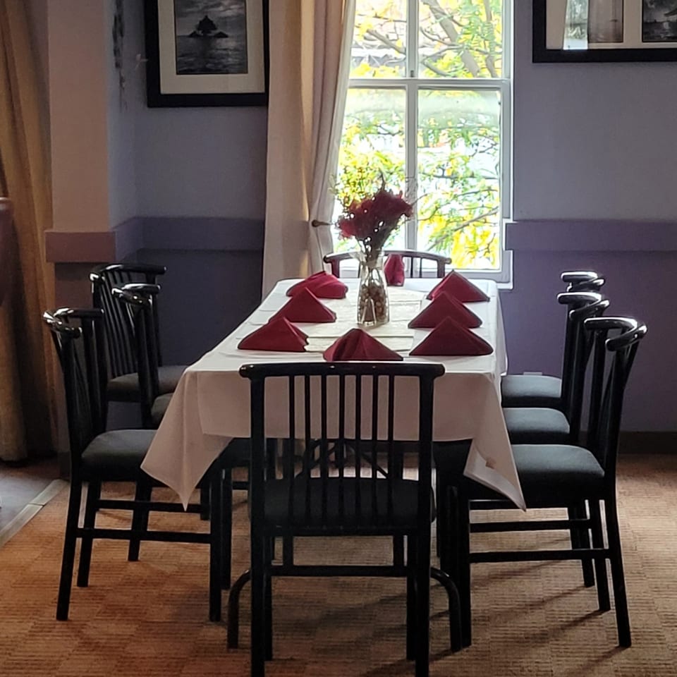 A dining table set with red napkins and a floral centerpiece, ready for guests at Stan & Joe's Saloon.